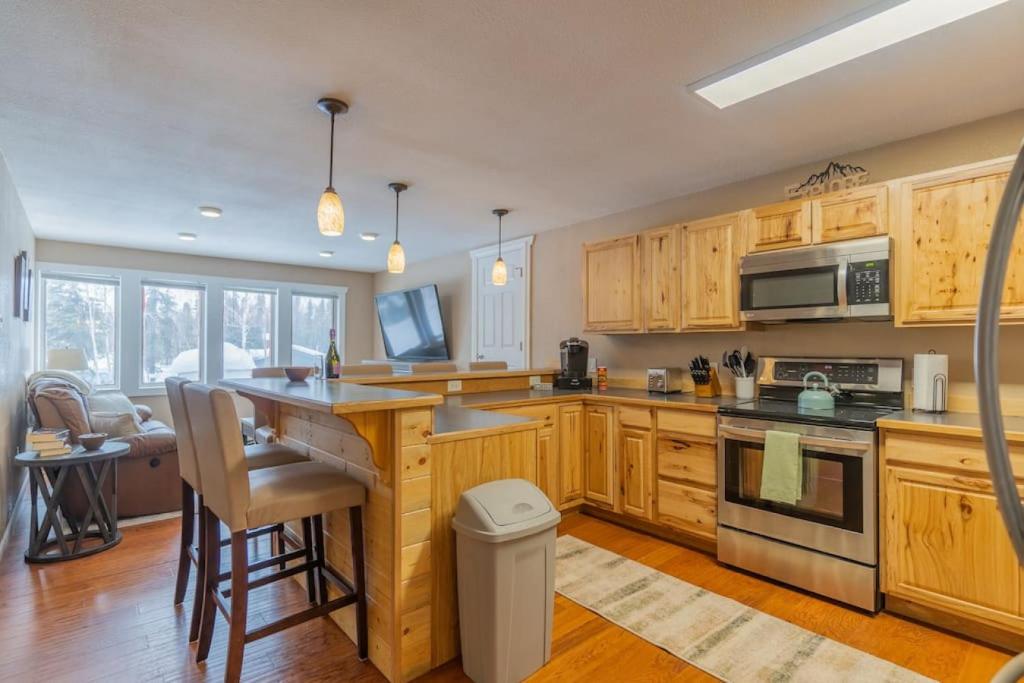 a kitchen with wooden cabinets and a counter top at The Airport Chalet in Fairbanks