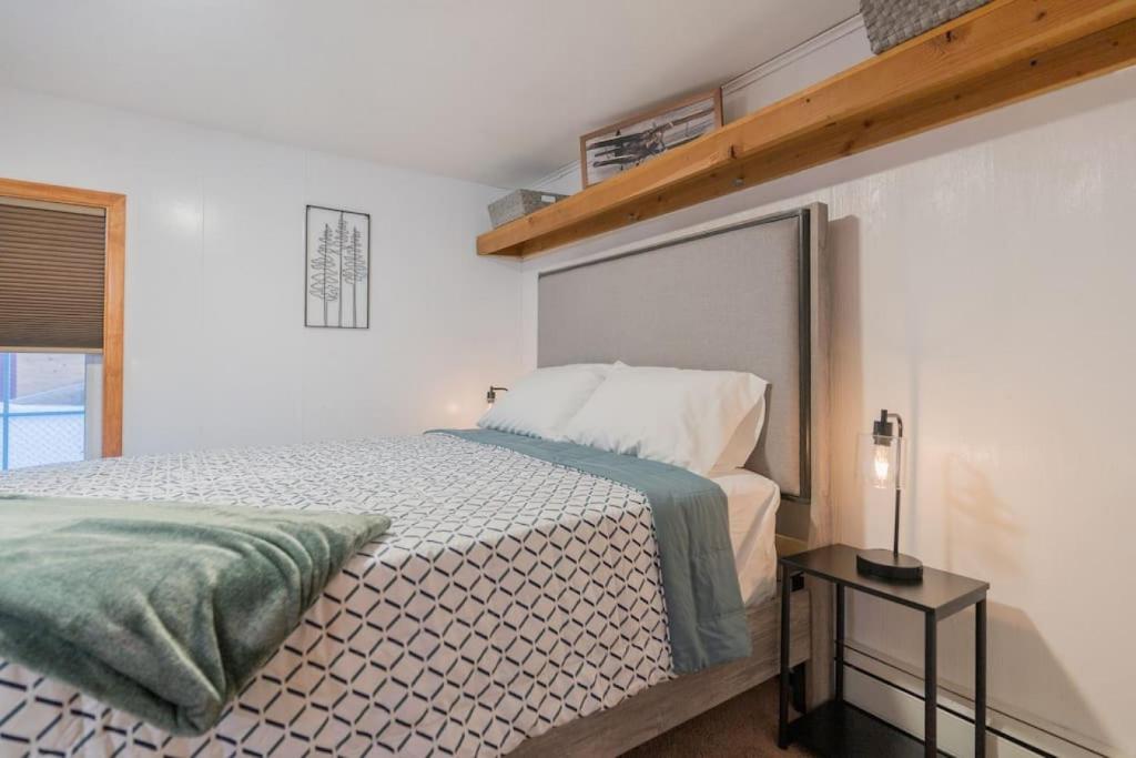 een slaapkamer met een bed in een witte kamer bij The Little Airport Getaway in Fairbanks