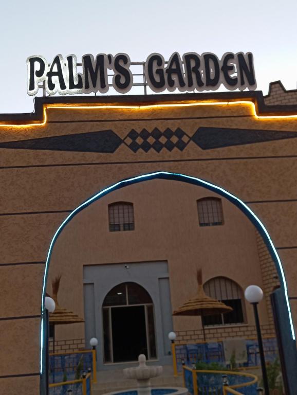 un bâtiment avec un panneau qui lit les palmiers du jardin dans l'établissement Palms Garden, à Erfoud