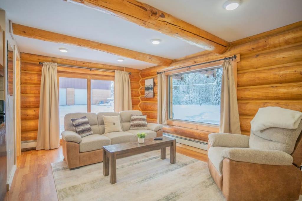 un soggiorno con 2 sedie e un tavolo di Tucked Away Timber Lower Suite a Fairbanks