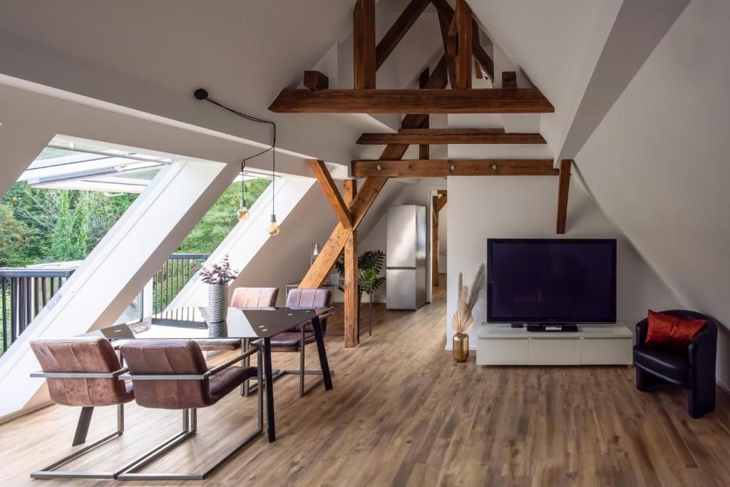a living room with a tv and wooden floors at DESIGN-Studio CHURCH 46 in Mülheim an der Ruhr
