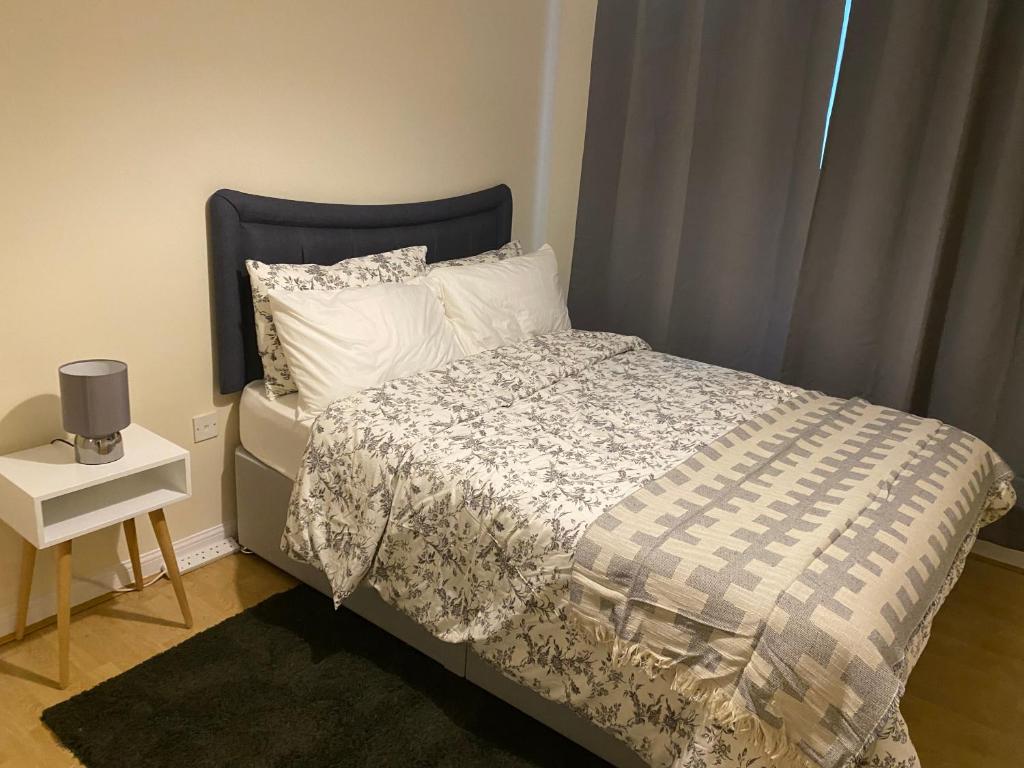 een slaapkamer met een bed en een nachtkastje met een bed sidx sidx bij Impeccable 2-Bed Apartment in London in Londen