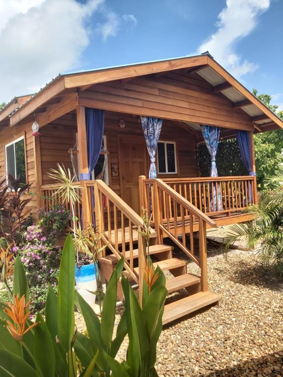 a log cabin with a deck and a porch at Bella Vita Casitas in Placencia Village