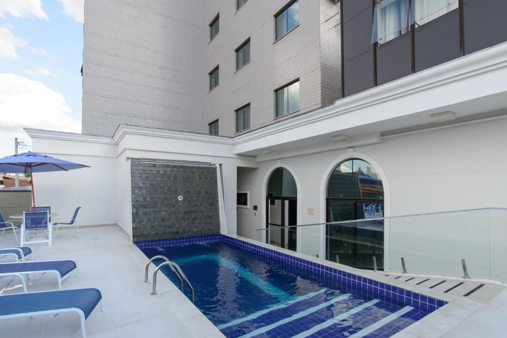 a swimming pool in front of a building at Faro Hotel Taubaté in Taubaté