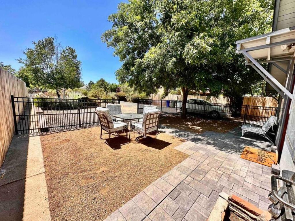 een patio met een tafel en stoelen en een hek bij The Virginia Blue Walk To Downtown Prescott in Prescott