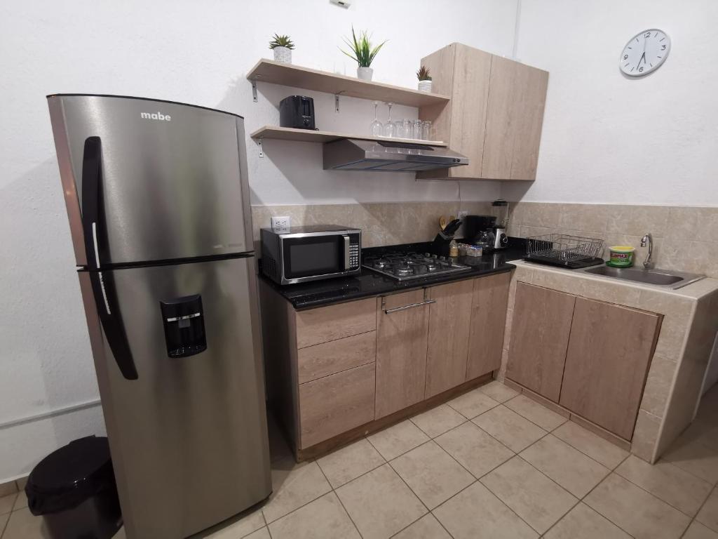 eine Küche mit einem Kühlschrank aus Edelstahl und einer Mikrowelle in der Unterkunft Casa de Primavera con Jacuzzi - Santa Ana in Santa Ana