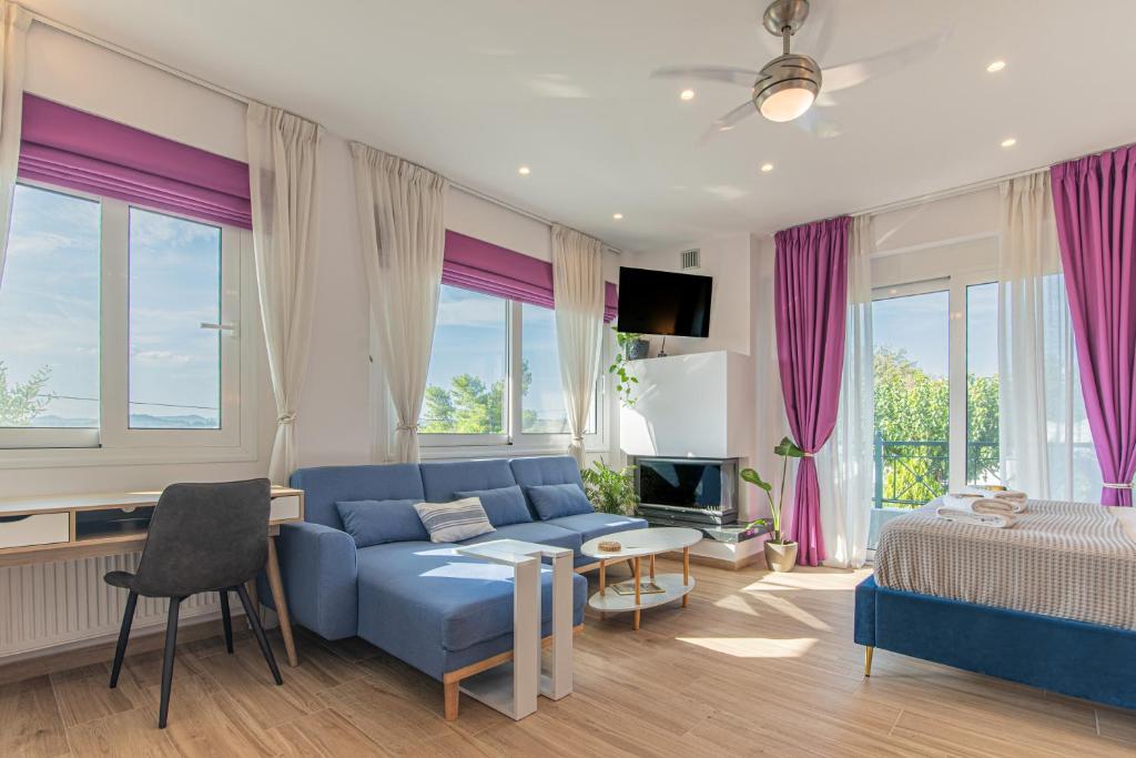 a living room with a blue couch and a bed at Levada Apartment in Avlón