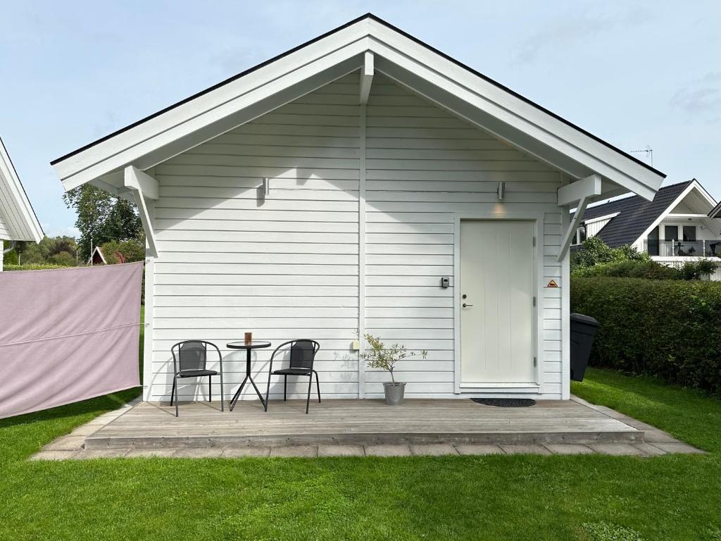 un cobertizo blanco con 2 sillas y una mesa en Guesthouse centrally in Vetlanda en Vetlanda