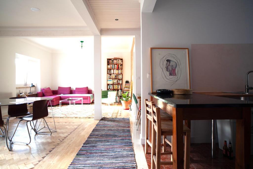 eine Küche und ein Wohnzimmer mit einem Tisch und einem Sofa in der Unterkunft Freshly reno'd flat in between Lisbon and Sintra in Amadora