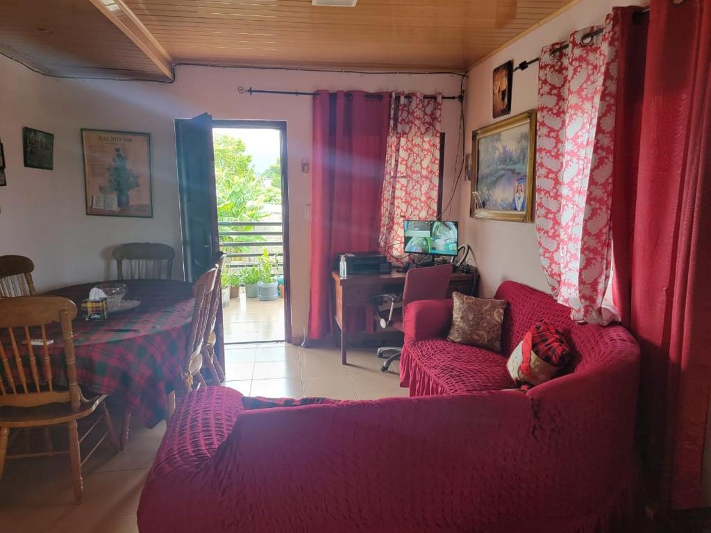 a living room with a red couch and a table at Alojamientos Hermanos Zambranos in Cabra