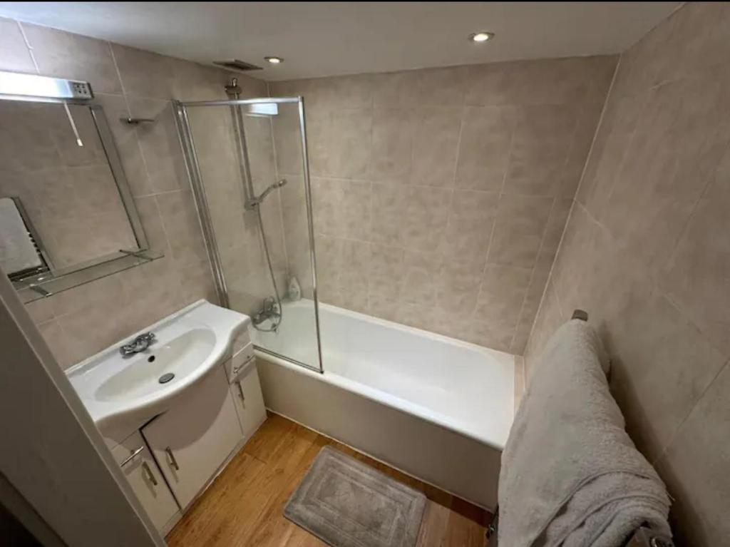 a bathroom with a tub and a sink and a shower at Charming studio in bond street in London