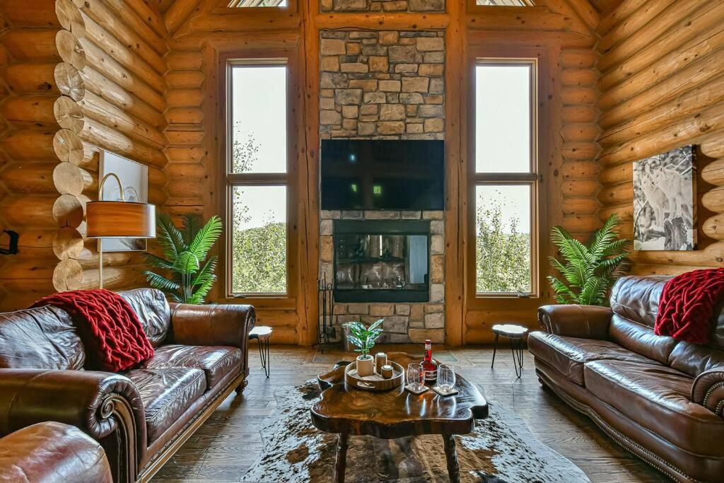 a living room with leather couches and a fireplace at Eagle's Nest in Saint-Faustin