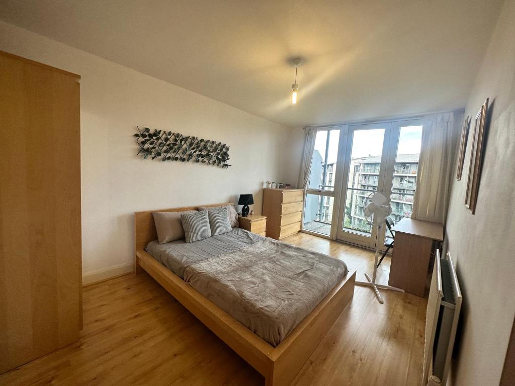 a bedroom with a bed and a large window at Ensuite Double Bedroom In Shared Apartment in Birmingham