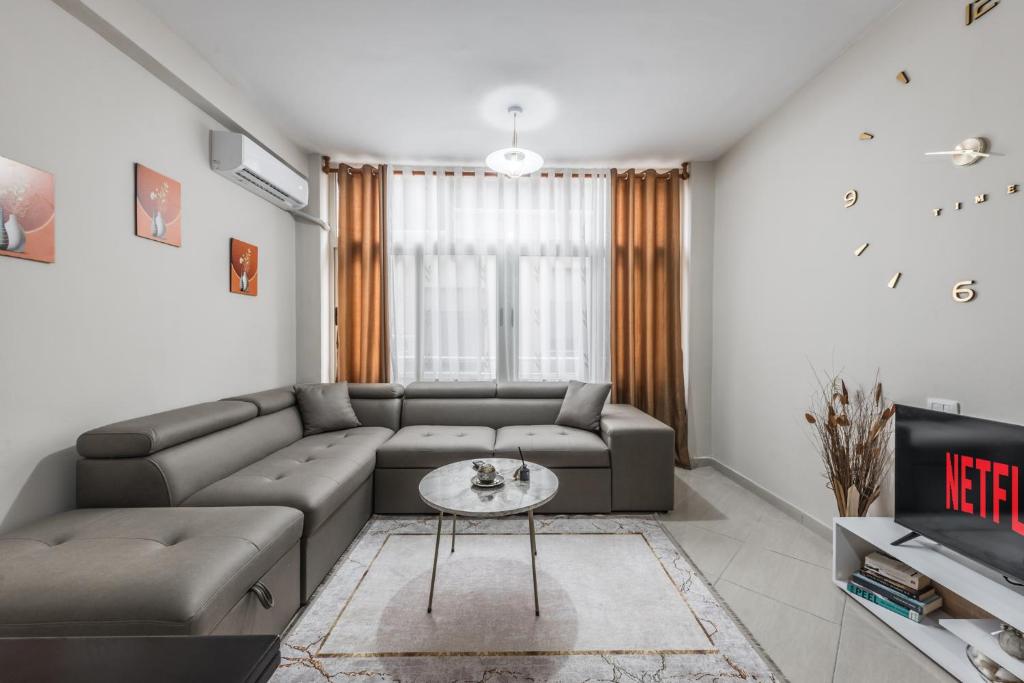 uma sala de estar com um sofá e uma mesa em Brand New Apartment- Great location Seafront with pool access em Durrës