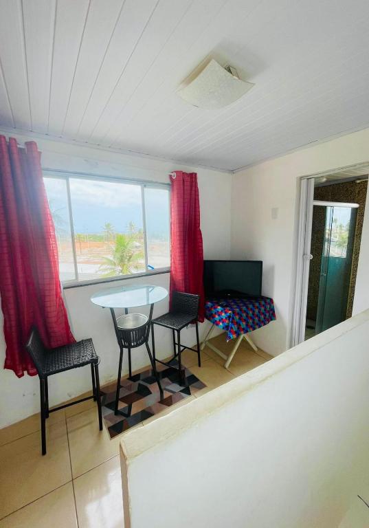 um quarto com uma mesa e cadeiras e uma janela em Mini Casa Vista Mar em Salvador