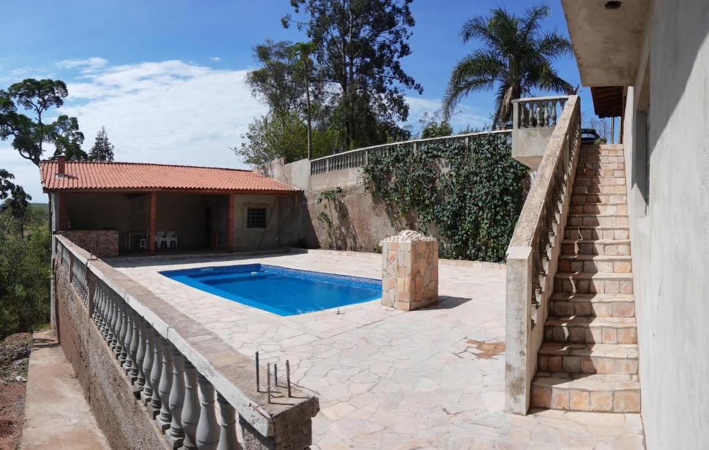 una casa con piscina al lado de una escalera en Chacara dos ipes, en São Roque