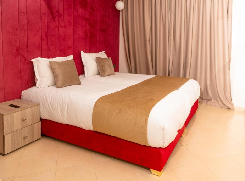 1 dormitorio con 1 cama grande y cabecero rojo en Residence La Perle de l'Atlas Marrakech, en Marrakech