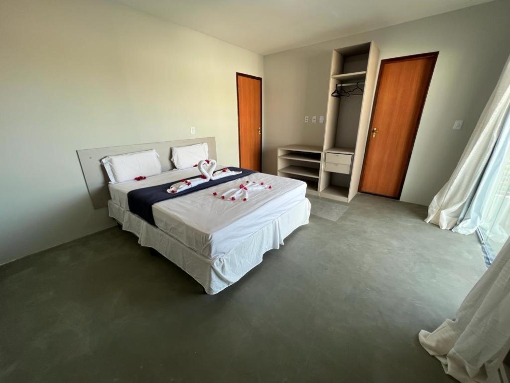 ein Schlafzimmer mit einem Bett mit roten Rosen darauf in der Unterkunft Paraíso Barra Grande in Barra Grande