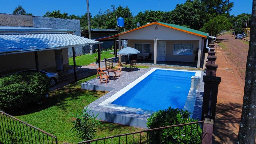 uma casa com piscina em frente a uma casa em Lumay em Puerto Iguazú