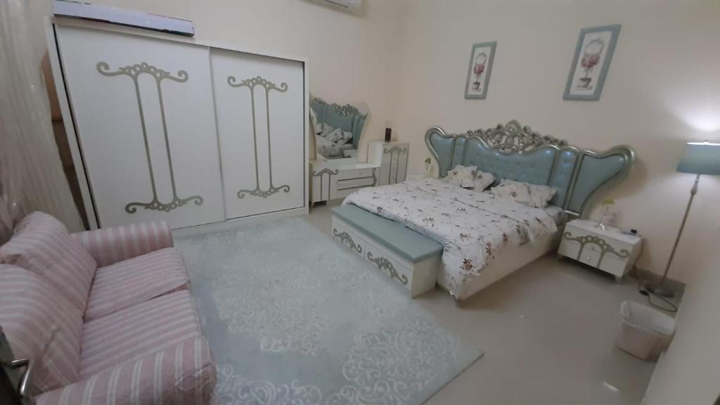 - une chambre avec un lit et un canapé dans l'établissement العين الهيلي مصباح بيت 3, à Al-Aïn