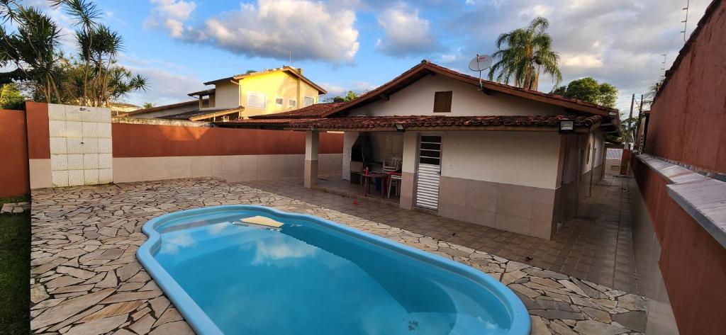 a swimming pool in the backyard of a house at Casa em Caraguatatuba com piscina e churrasqueira in Caraguatatuba