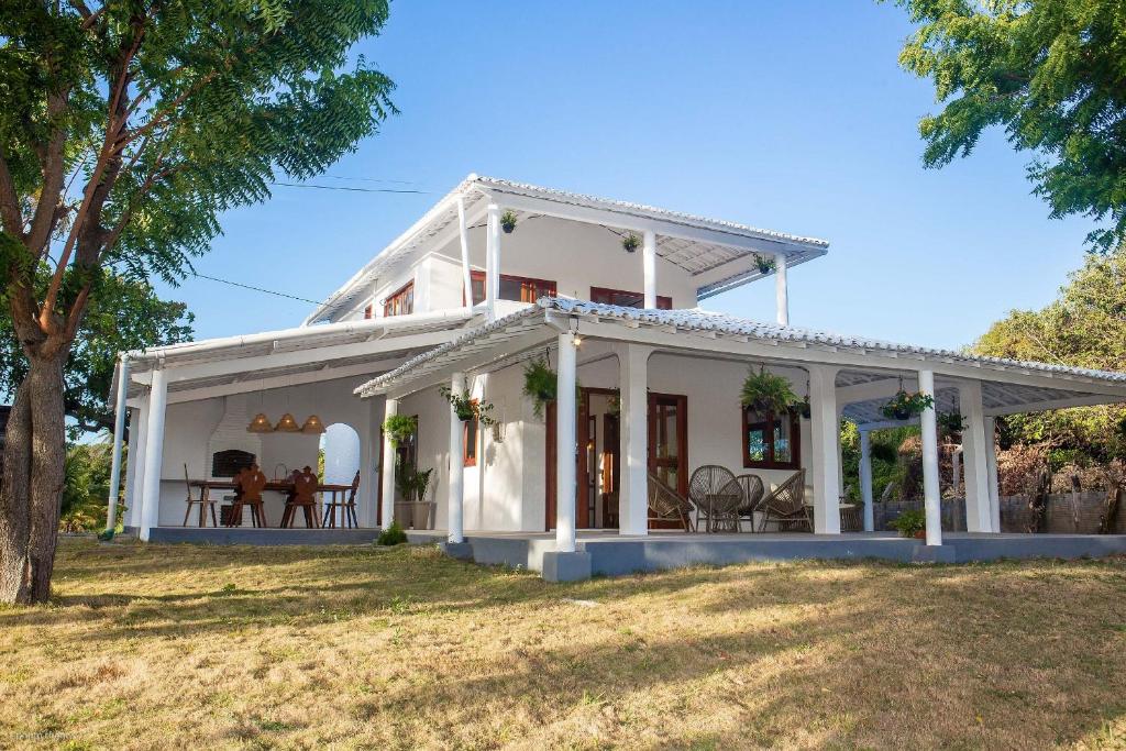 una casa bianca con portico di Casa Blue Parrot – Um Paraíso na Praia da Taíba a São Gonçalo do Amarante