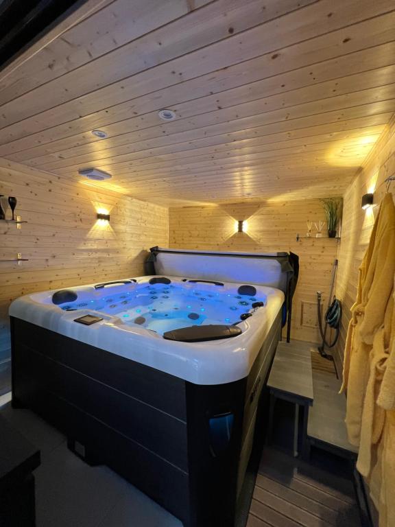 Les suites de Stanislas jacuzzi & spa في نانسي: حوض جاكوزي في غرفة مع جدران خشبية