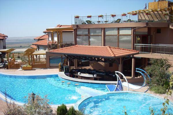 un gran edificio con una piscina frente a él en Captivating, 1 Bedroom at Bay View Villas, en Kosharitsa