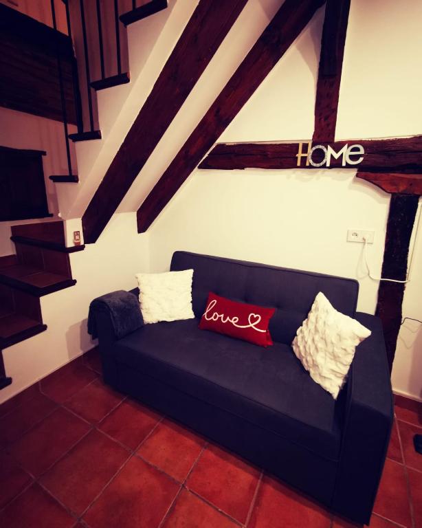 a black couch in a living room with a love sign at Holiday Duplex Casco Antiguo in Logroño