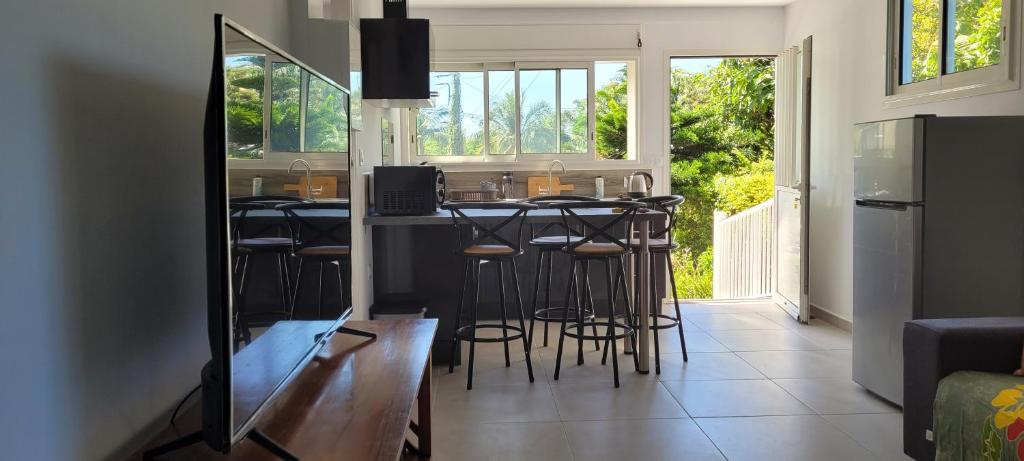 a kitchen with a bar with stools in it at MON CHEZ MOI in Le Tampon