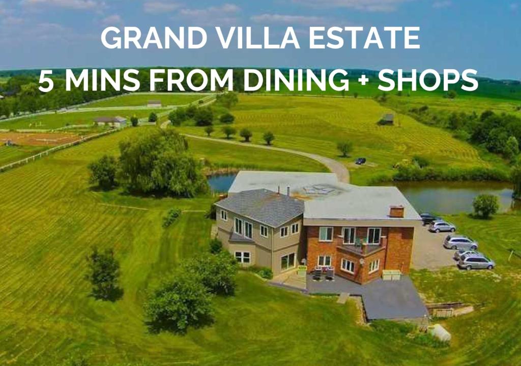 une grande maison sur une colline herbeuse avec les mots majestueux domaine 5 dans l'établissement Grand Villa Estate, à Burlington