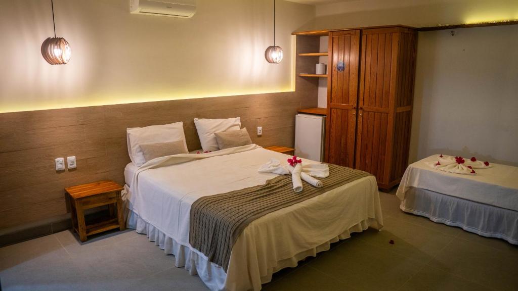 um quarto de hotel com duas camas com flores em Hotel Chale Nosso Sítio em Guaramiranga