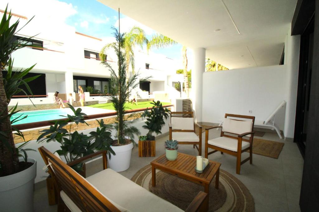 a patio with chairs and a table and a pool at Elvira Home, Santiago de la Ribera, AQ-156 in Santiago de la Ribera