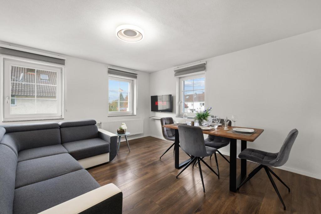 a living room with a couch and a table at ADN Suites - NETFLIX - modern and smart in Günzburg