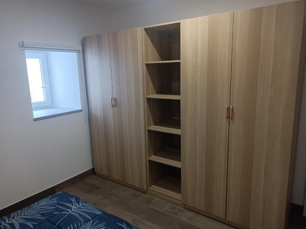 een slaapkamer met een houten kast en een bed bij Casa Amado Fundão in Fundão