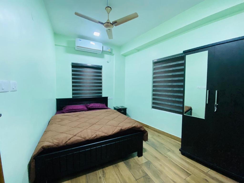 a bedroom with a bed and a ceiling fan at AL-Kabeer Lavender budget rooms in Trivandrum