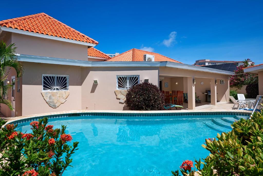 una piscina frente a una casa en Aruba Palm Beach Villa, en Palm-Eagle Beach