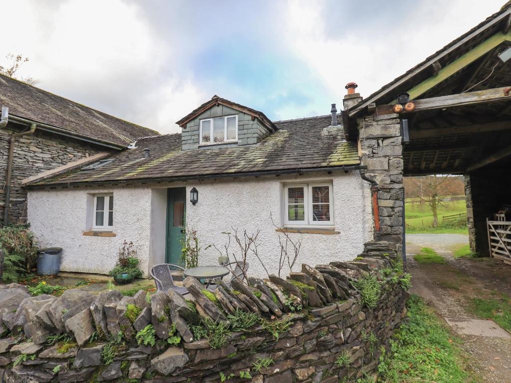 a white brick house with a stone wall at Jane's Cottage in Ambleside