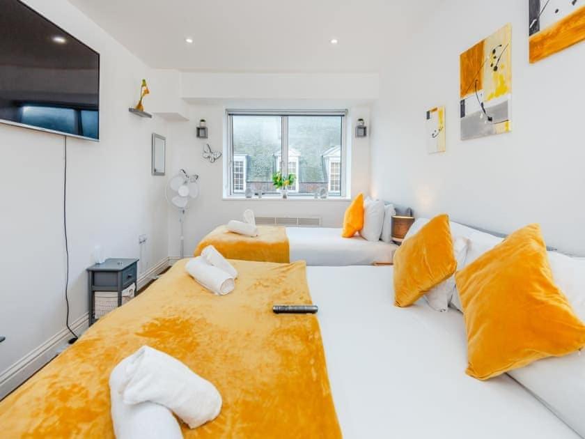 Habitación blanca grande con 2 camas y almohadas amarillas. en Ws Apartments - Luxury 1 bed in Watford Central, en Watford