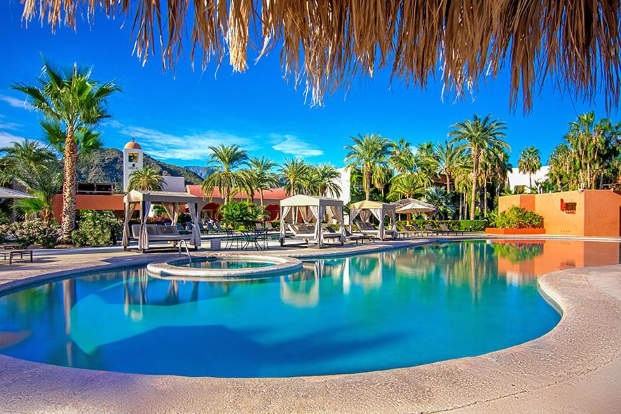 a swimming pool at a resort with palm trees at Loreto Bay Golf Resort & Spa at Baja in Loreto