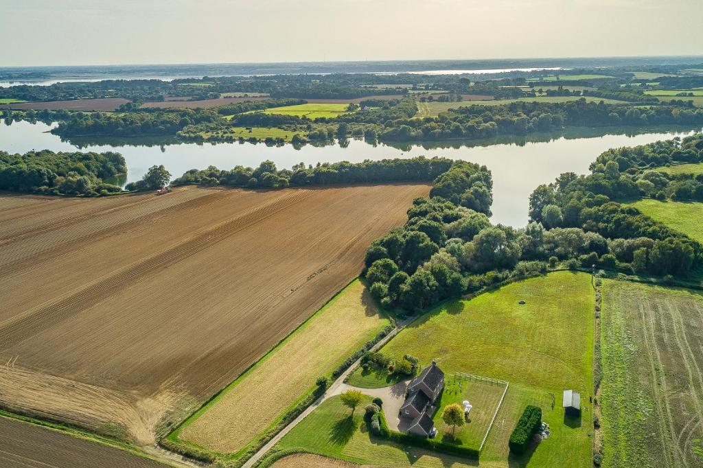una vista aérea de una granja y un río en Family water sports and cycling getaway - The Lake House en Ipswich