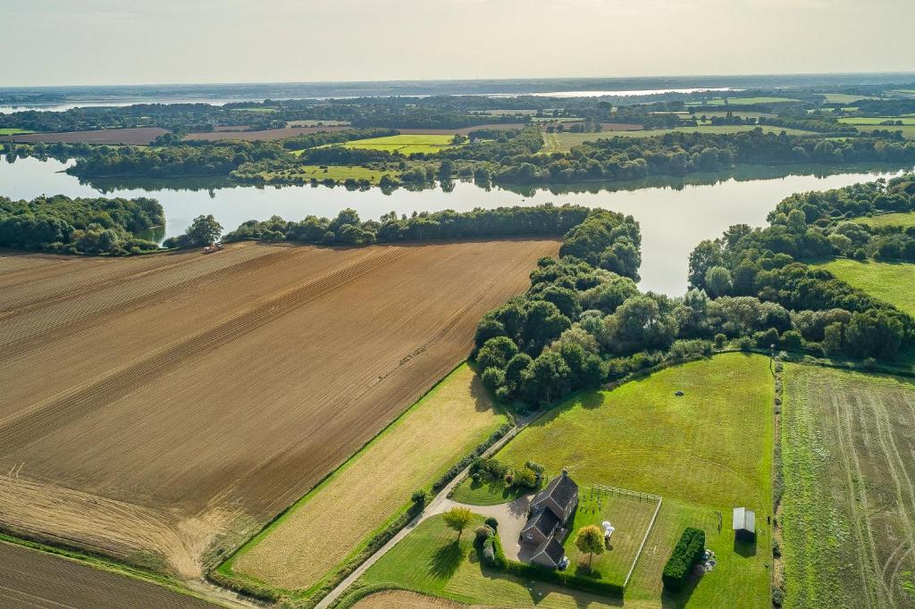 an aerial view of a farm and a river at Family water sports and cycling getaway - The Lake House in Ipswich