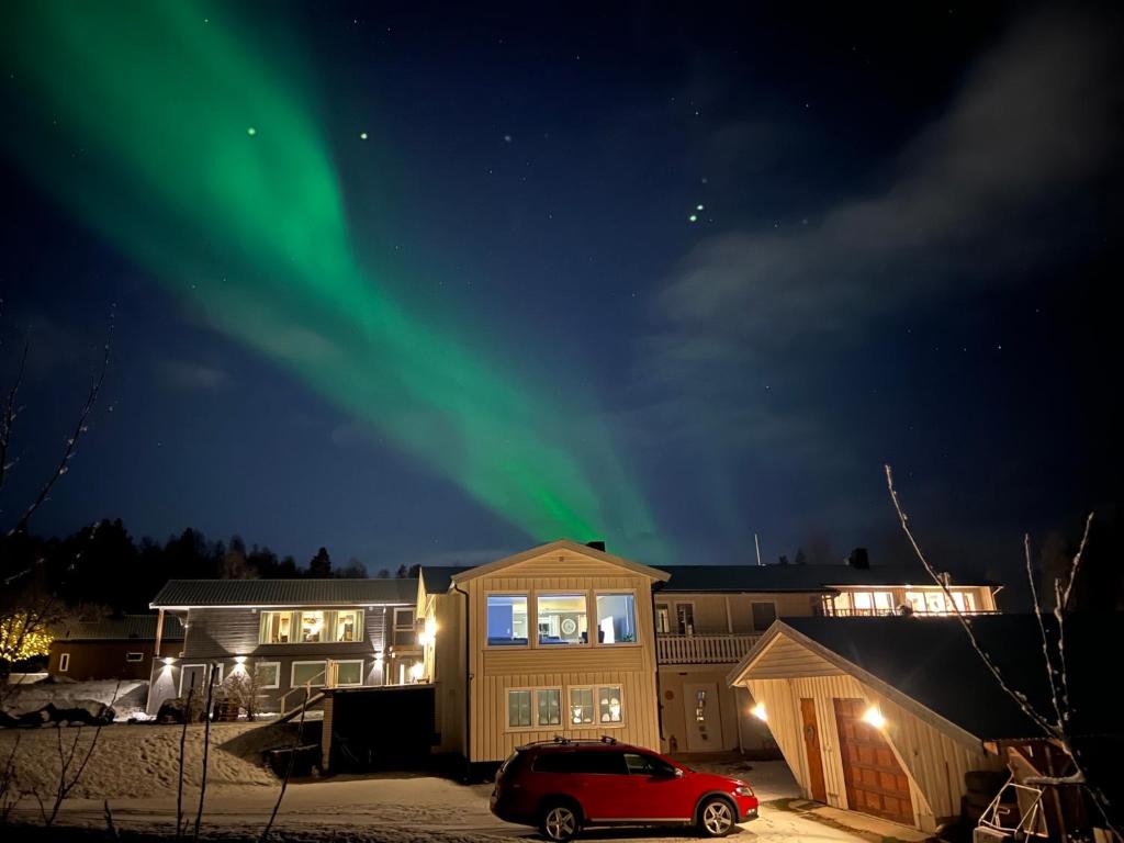 a house with the green northern lights in the sky at Marta's Home-cozy appartment near the Airport in Andselv
