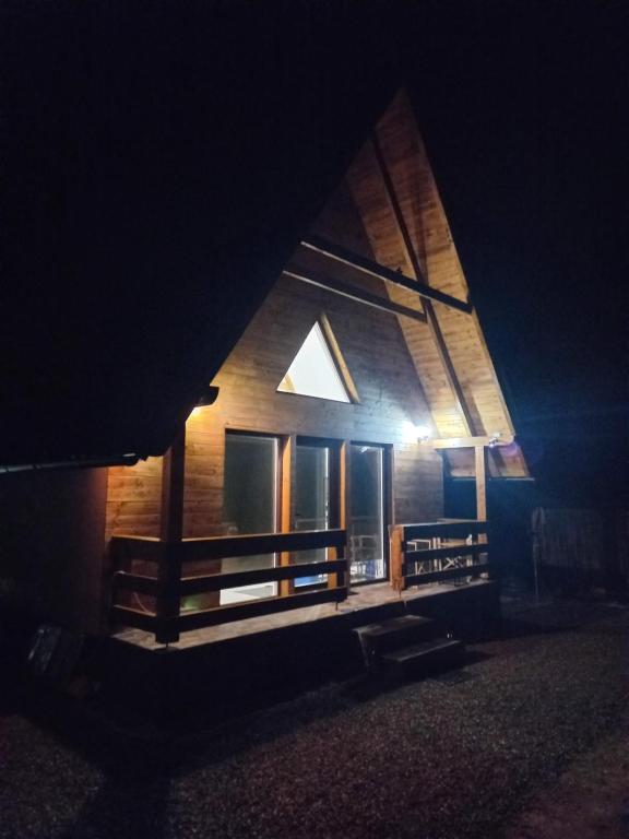 een houten huis 's nachts met een licht erop bij ALI HOUSE in Poiana Fagului