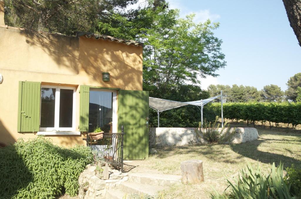 a house with a green door and a fence at Le petit Bacalan in Mormoiron