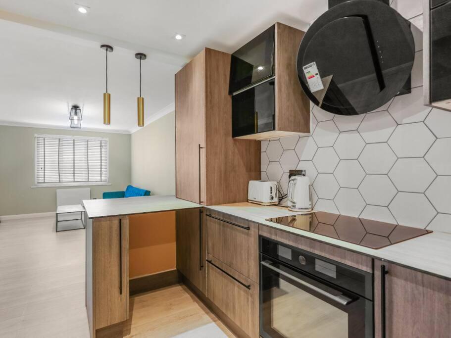 a kitchen with wooden cabinets and a counter top at Luxury Apartment in Kingston in Kingston upon Thames