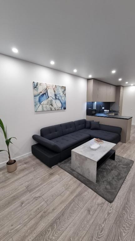 un soggiorno con divano nero e tavolo di New apartment in the city a Šiauliai