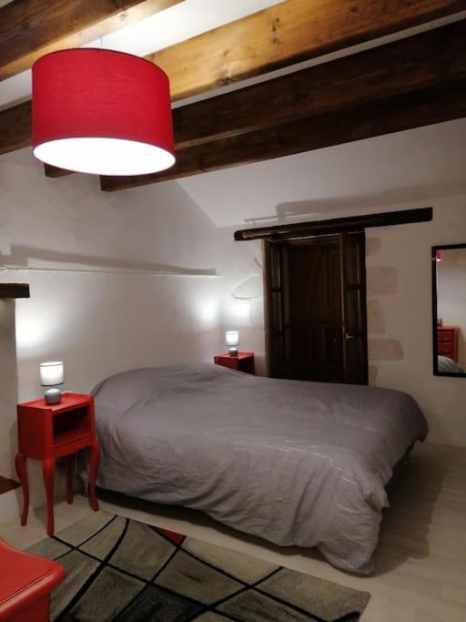 une chambre avec un lit et une lampe rouge dans l'établissement LE BLANC, AGREABLE MAISON DE CENTRE VILLE, à Le Blanc