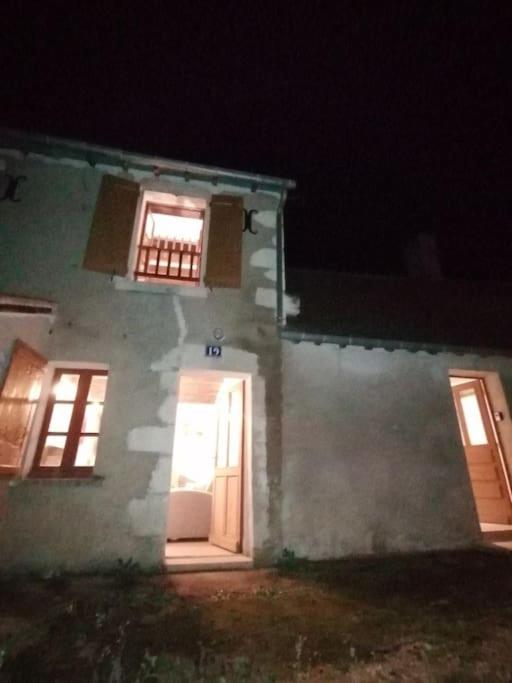 a white house with a door and windows at night at LE BLANC, AGREABLE MAISON DE CENTRE VILLE in Le Blanc