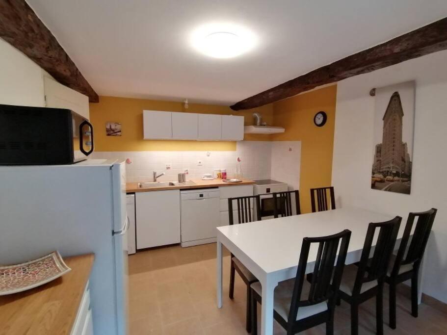 a kitchen with a table and chairs and a refrigerator at LE BLANC, AGREABLE MAISON DE CENTRE VILLE in Le Blanc